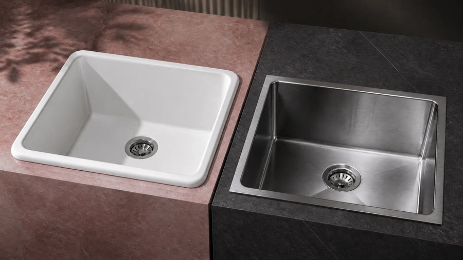 A glossy white sink beside a brushed stainless steel sink on contrasting stone counters