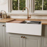 33 inch fireclay double bowl farmhouse sink with the smooth apron side facing out, cutting board over one bowl and roll-up drying rack over the other