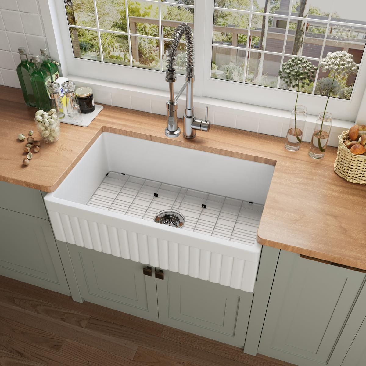 NOZLOO 33 inch reversible fluted apron fireclay farmhouse sink with bottom grid, top view in a sage green kitchen