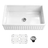 33 inch reversible apron fireclay farmhouse sink shown with fluted front, stainless steel bottom grid, and drain assembly.