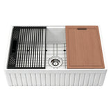 NOZLOO 33-inch fluted apron fireclay farmhouse workstation sink with included sapele cutting board, roll-up drying rack, black colander, and stainless steel bottom grid on a white background